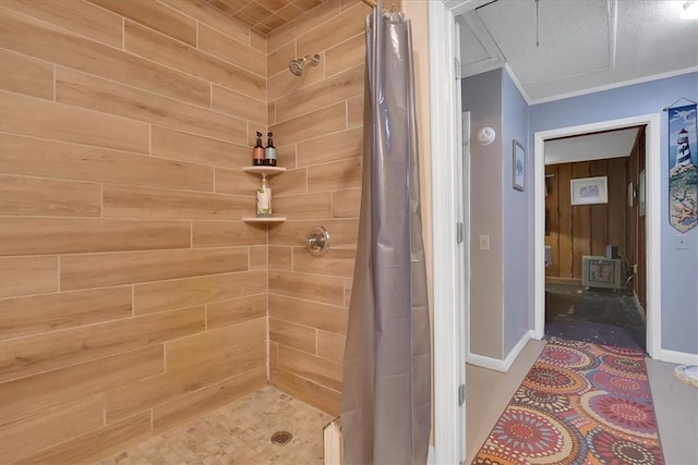 full bathroom with a wood stove, a shower stall, ornamental molding, and baseboards