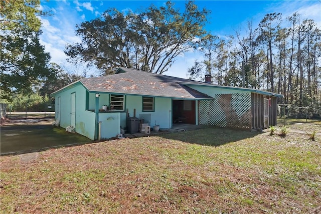 back of house with fence and a yard