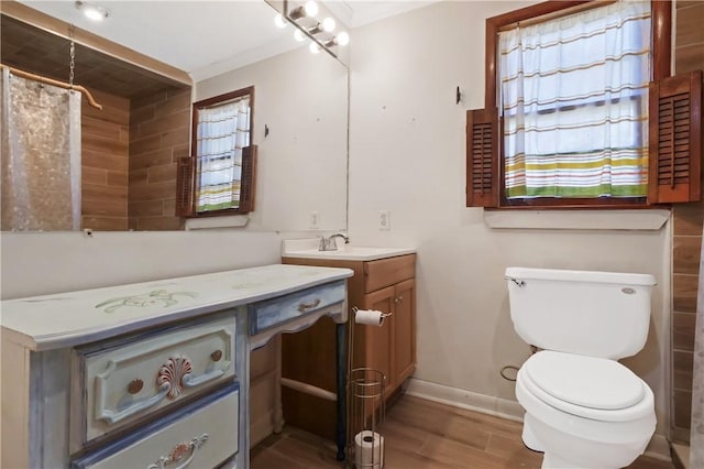 full bath featuring baseboards, a shower with shower curtain, toilet, wood finished floors, and vanity