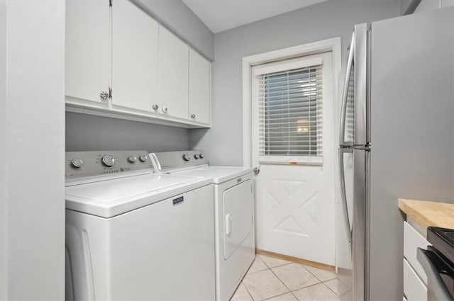 clothes washing area with light tile patterned flooring and independent washer and dryer