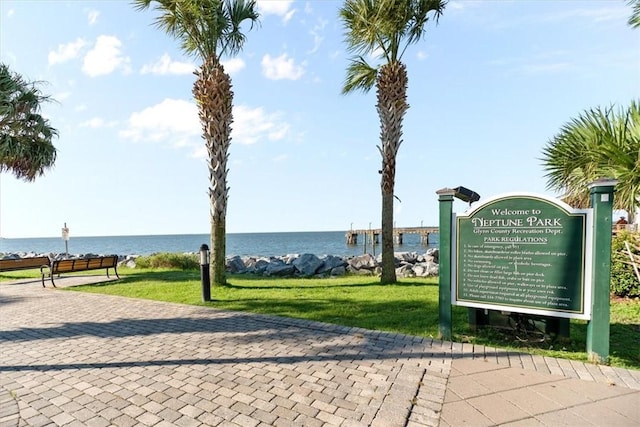 view of property's community with a water view and a yard