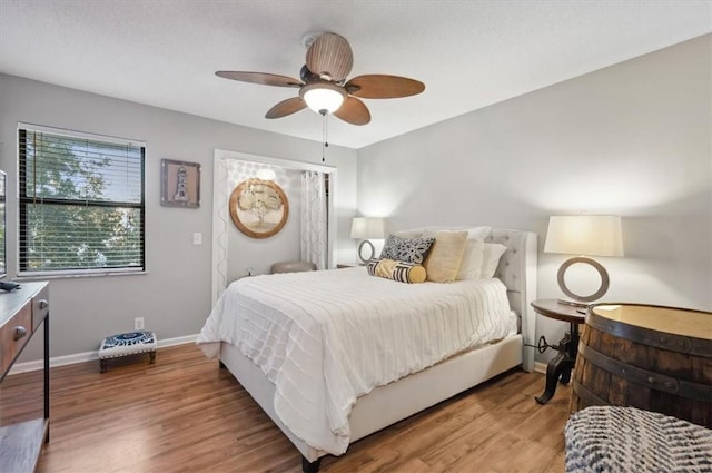 bedroom with wood-type flooring and ceiling fan