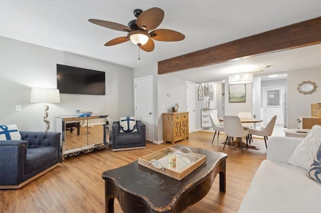 living room with ceiling fan, hardwood / wood-style floors, beamed ceiling, and a textured ceiling