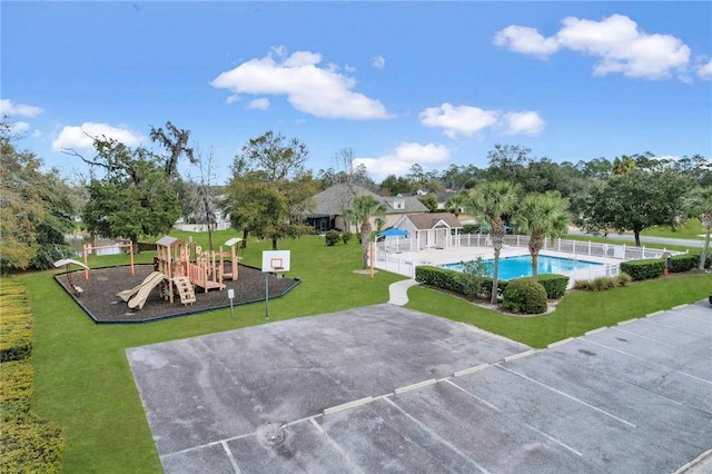 view of swimming pool with a lawn and a playground