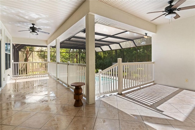 view of patio featuring an outdoor pool, glass enclosure, and ceiling fan