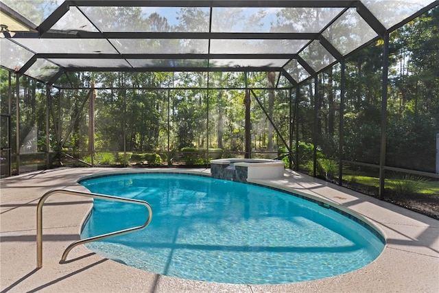 view of pool with a pool with connected hot tub, glass enclosure, and a patio