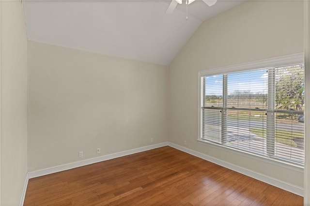 empty room featuring a ceiling fan, baseboards, vaulted ceiling, and wood finished floors