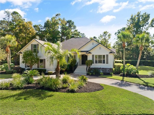 view of front facade featuring stucco siding, concrete driveway, and a front yard