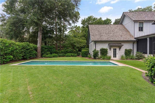 view of pool featuring a lawn