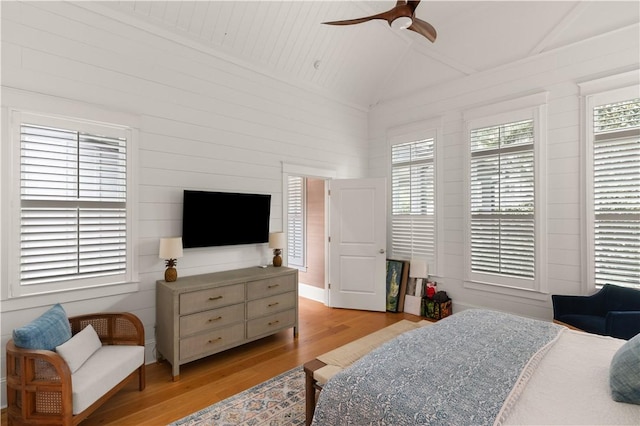 bedroom with ceiling fan, light wood-type flooring, and lofted ceiling