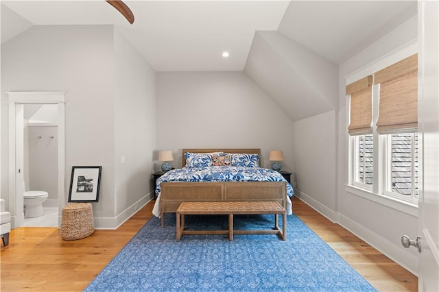 bedroom with hardwood / wood-style floors, ensuite bathroom, ceiling fan, and lofted ceiling