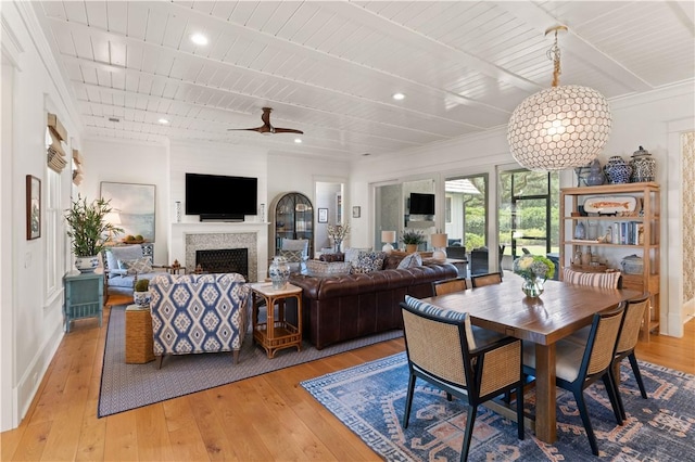 dining room with light wood-type flooring, ceiling fan, and wooden ceiling