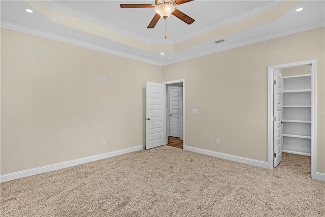 838 Old Ccc Rd, Brunswick, GA 31523 - unfurnished bedroom with a walk in closet, a tray ceiling, ceiling fan, and crown molding