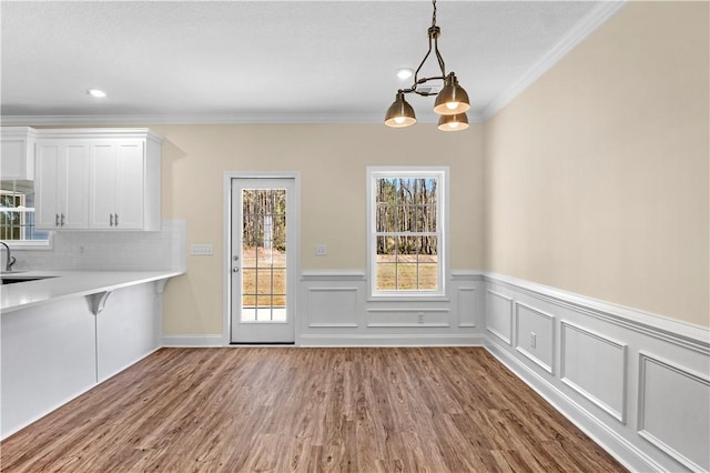 838 Old Ccc Rd, Brunswick, GA 31523 - unfurnished dining area with hardwood / wood-style flooring, a chandelier, and ornamental molding