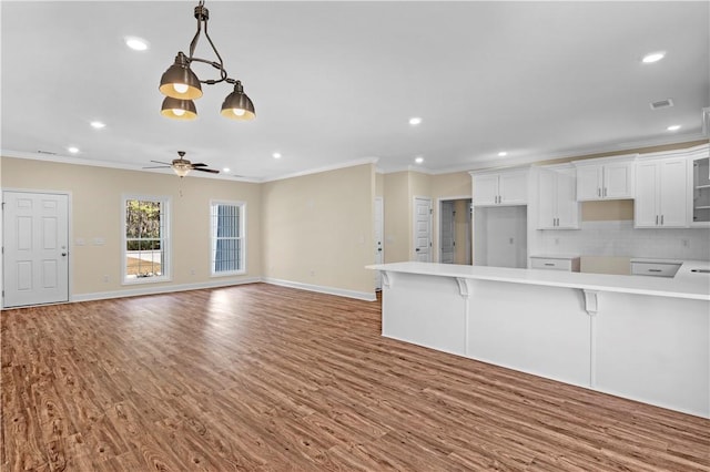 838 Old Ccc Rd, Brunswick, GA 31523 - kitchen featuring a kitchen breakfast bar, backsplash, ornamental molding, decorative light fixtures, and white cabinets