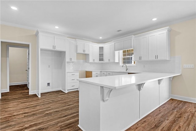 838 Old Ccc Rd, Brunswick, GA 31523 - kitchen featuring white cabinets, a kitchen breakfast bar, dark hardwood / wood-style flooring, and crown molding