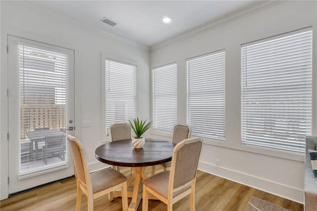 dining area featuring light hardwood / wood-style floors and crown molding