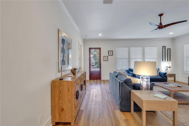 living room featuring ceiling fan, ornamental molding, and light hardwood / wood-style flooring