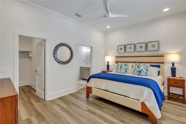 bedroom featuring ceiling fan, a spacious closet, light hardwood / wood-style flooring, connected bathroom, and a closet