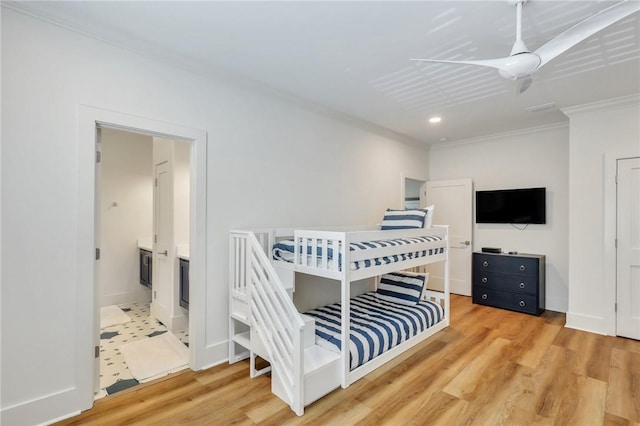 bedroom featuring crown molding, ensuite bathroom, and hardwood / wood-style flooring