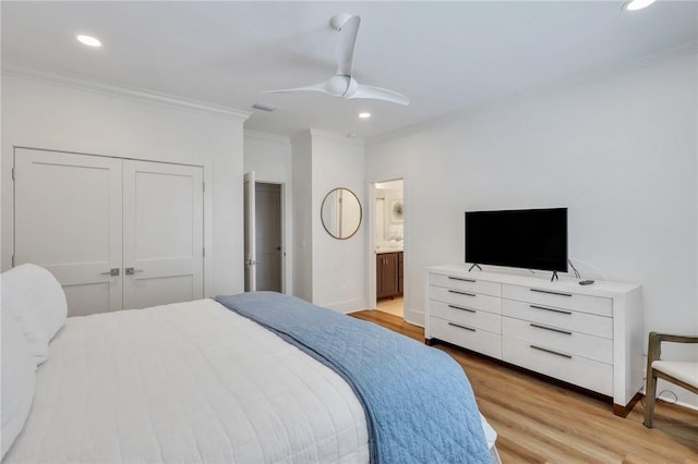 bedroom featuring ensuite bathroom, light hardwood / wood-style flooring, ceiling fan, ornamental molding, and a closet