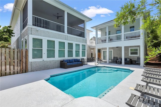 rear view of house with a fenced in pool, ceiling fan, a patio, and an outdoor hangout area