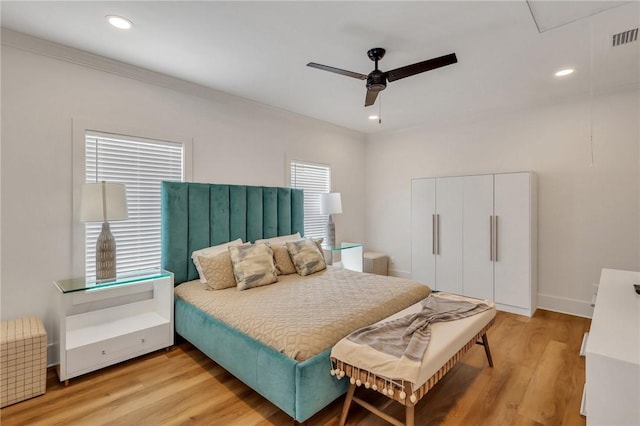 bedroom with light wood-type flooring, ceiling fan, and crown molding