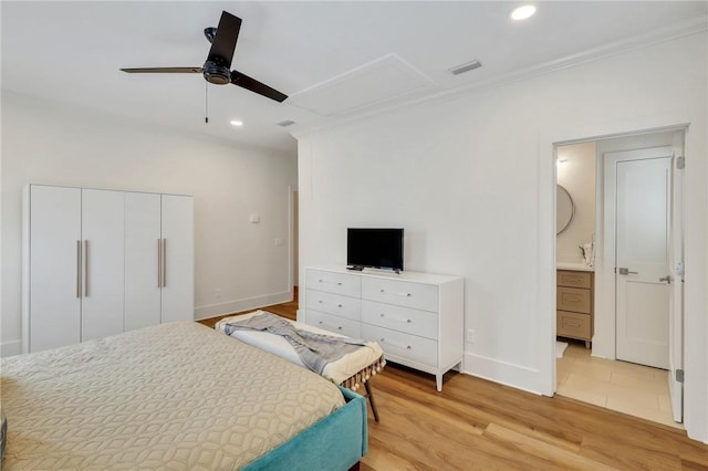 bedroom featuring ceiling fan, a closet, ensuite bathroom, and light wood-type flooring