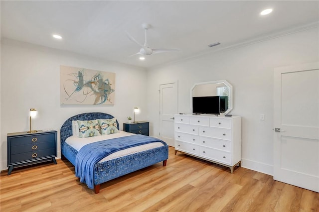 bedroom with light wood-type flooring, ceiling fan, and ornamental molding