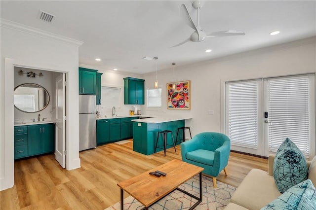 living room with ceiling fan, light hardwood / wood-style floors, sink, and a wealth of natural light