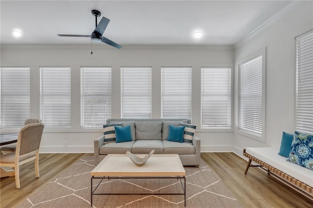 living room featuring light hardwood / wood-style floors, ceiling fan, and crown molding