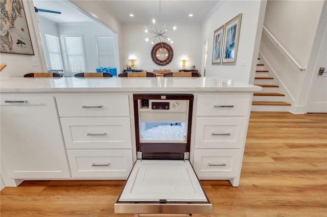 kitchen featuring white cabinets, pendant lighting, and light hardwood / wood-style floors