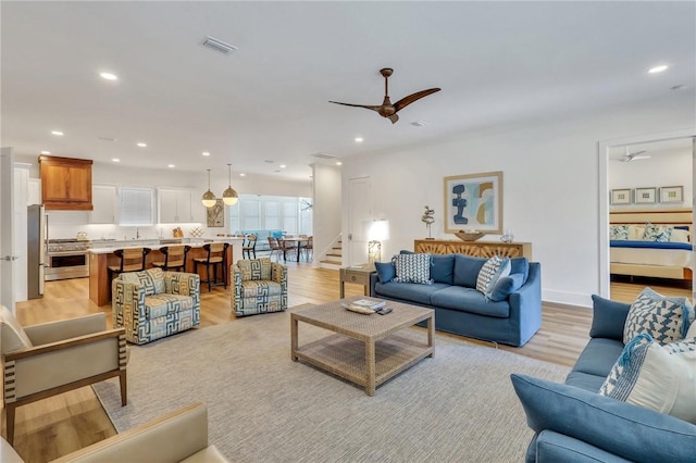 living room featuring ceiling fan and light wood-type flooring