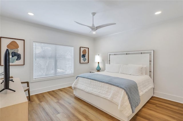 bedroom with light wood-type flooring, ceiling fan, and crown molding