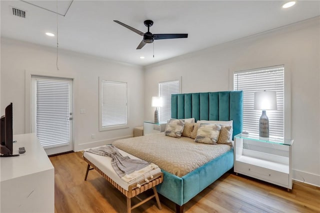 bedroom with hardwood / wood-style floors, ceiling fan, and crown molding