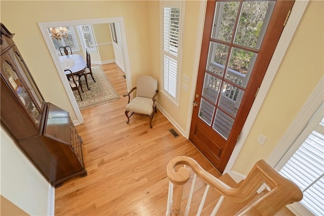 interior space featuring light wood-type flooring, visible vents, and baseboards