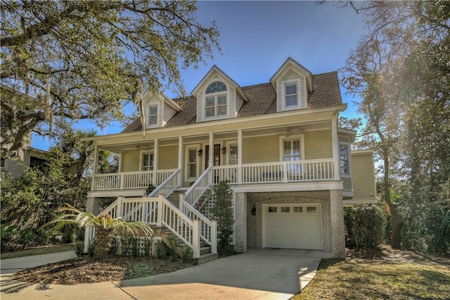 coastal inspired home featuring a porch, a garage, a shingled roof, stairs, and concrete driveway