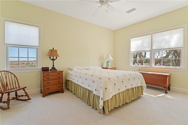 bedroom with baseboards, a ceiling fan, visible vents, and light colored carpet