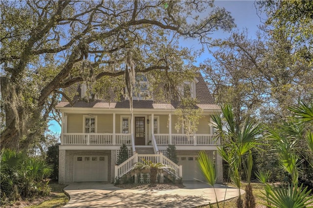 beach home with a porch, a shingled roof, an attached garage, driveway, and stairs