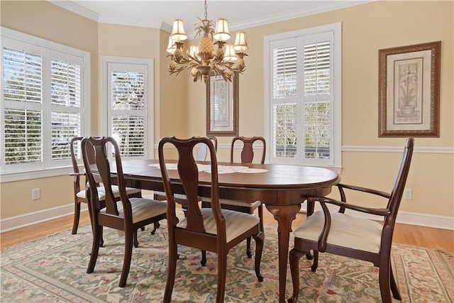 dining space with light wood-style flooring, ornamental molding, and baseboards