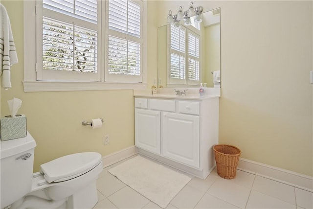 bathroom with vanity, tile patterned flooring, toilet, and baseboards