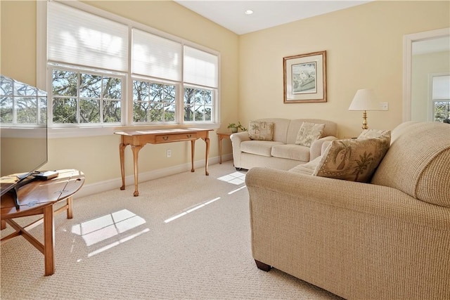 living room featuring recessed lighting, baseboards, and light colored carpet