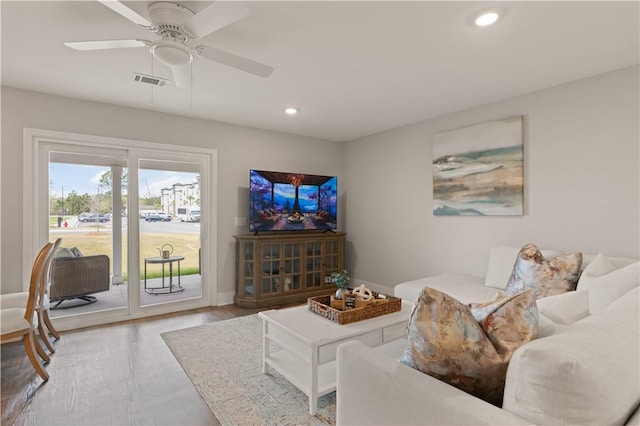 living room with light wood-type flooring and ceiling fan