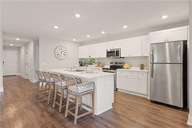 kitchen featuring white cabinetry, a kitchen island with sink, dark wood-type flooring, and stainless steel appliances