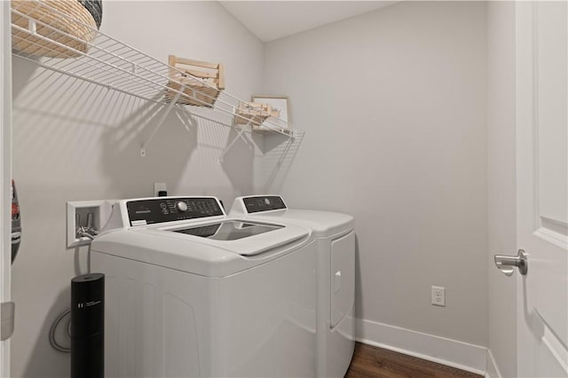 washroom with dark hardwood / wood-style floors and washing machine and dryer