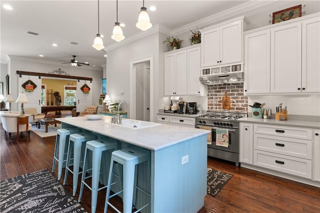 kitchen with dark hardwood / wood-style flooring, a kitchen island with sink, ceiling fan, double oven range, and white cabinetry