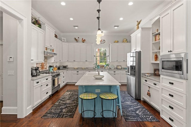 kitchen featuring pendant lighting, a center island, crown molding, white cabinetry, and stainless steel appliances