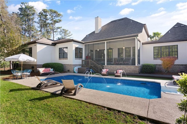 back of house with a yard, pool water feature, a patio, and a sunroom