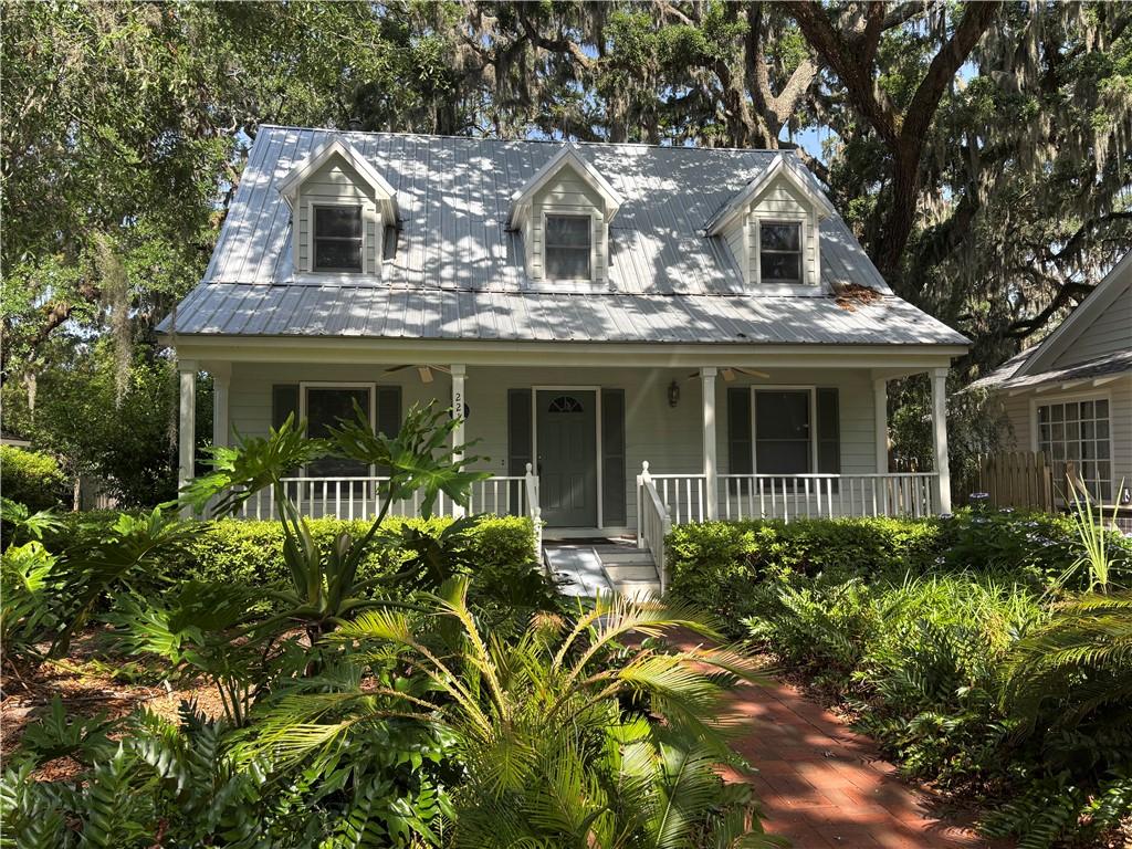 221 Broadway St, Saint Simons Island, GA 31522 - cape cod home with a porch and metal roof