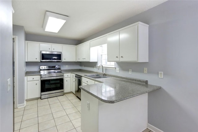 30 Bridgewater Way, Brunswick, GA 31525 - kitchen with appliances with stainless steel finishes, a sink, a peninsula, white cabinetry, and light tile patterned floors